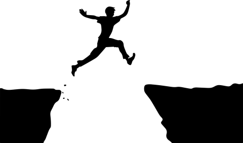 A person leaping from a cliff as it crumbles to reach the other side.