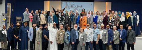 Educators from across the country visiting Brighter Horizons Academy and standing on stage for a group pic